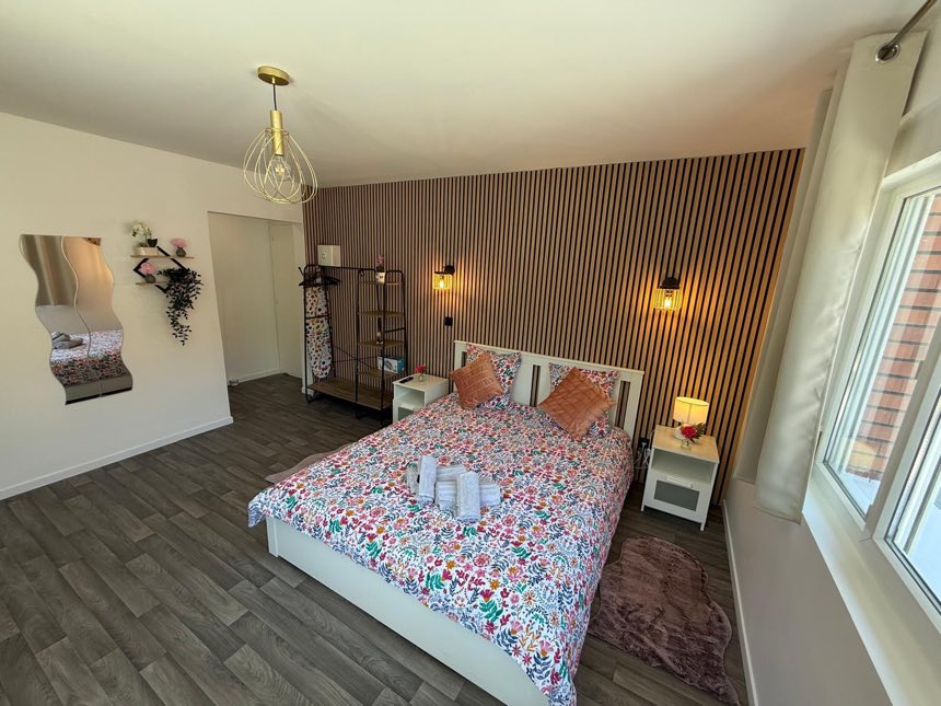 Chambre entièrement rénovée : mur en tasseaux de bois, appliques et parquet neufs