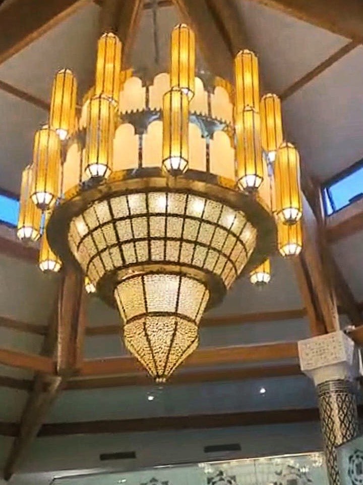 Lustre monumental installé et allumé sous la charpente de la Mosquée de Grigny