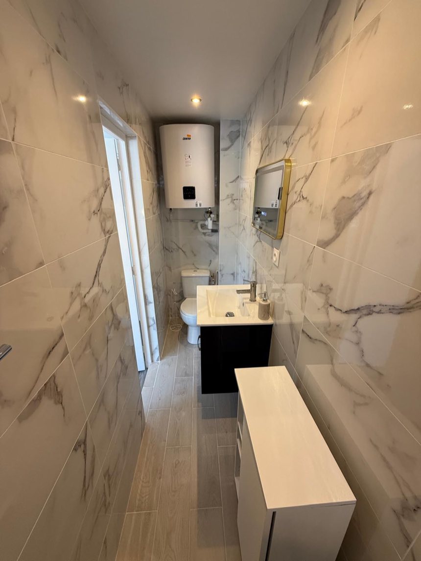 Salle de bains rénovée en marbre avec chauffe-eau installé